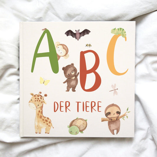 Buch ABC der Tiere mit niedlichen Handgemalten Tieren, darunter ein Bär, ein Affe, eine Giraffe und ein Faultier. Buchstaben ABC in Grün, Rot und Gelb.