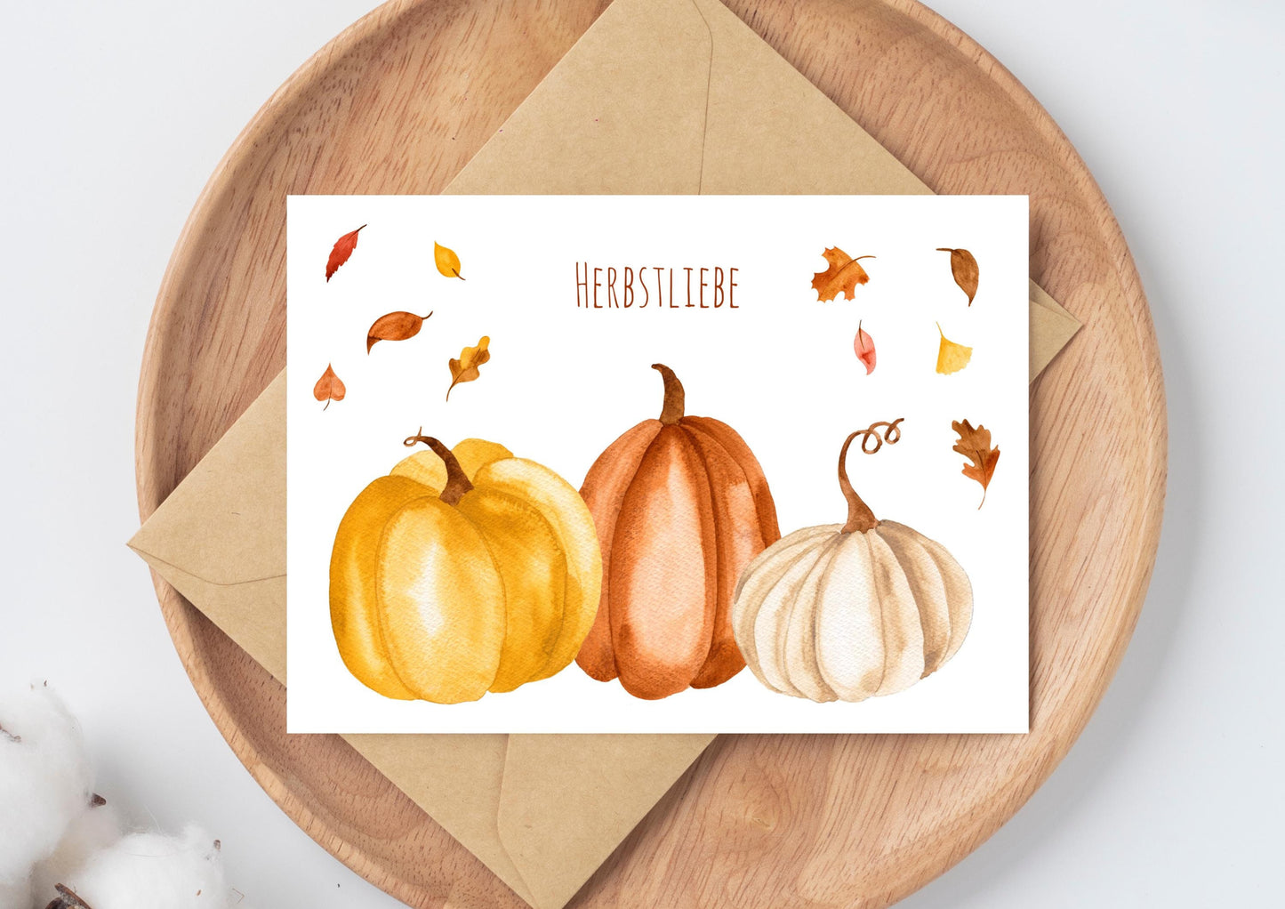 Postkarte Herbstliebe Kürbis & Herbstlaub A6, Kürbisse und Herbstblätter auf einem Holztablett, gedruckt auf mattem, unbeschichtetem 300g Naturpapier.