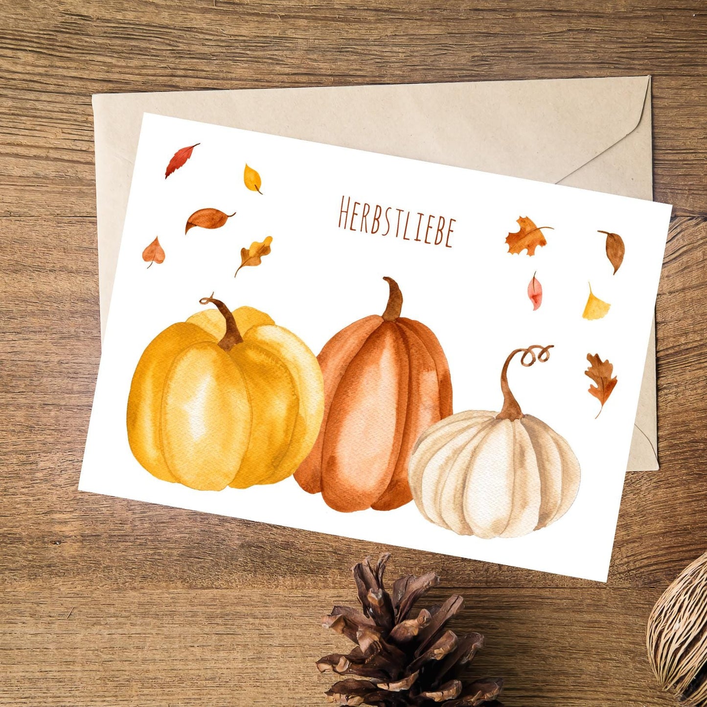 Postkarte Herbstliebe Kürbis & Herbstlaub A6 auf Holzfläche, Auqarell mit Kürbissen und Laub, Text Herbstliebe, perfekt für Herbstgrüße oder Dekoration.