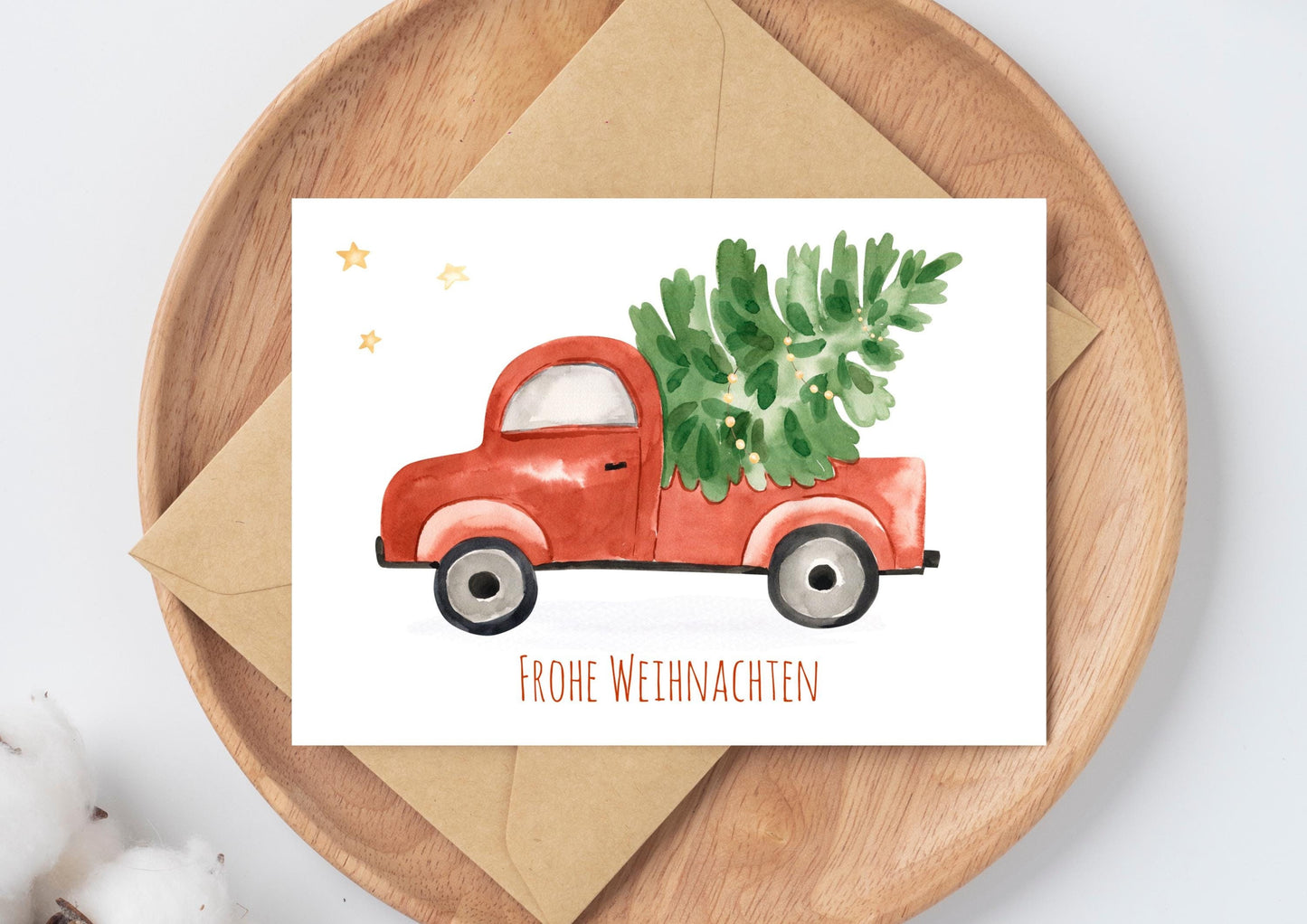 Weihnachtskarte mit rotem Auto, das einen Weihnachtsbaum transportiert, und Frohe Weihnachten Schriftzug. Gedruckt auf stabilem 300g Naturpapier, Größe A6.