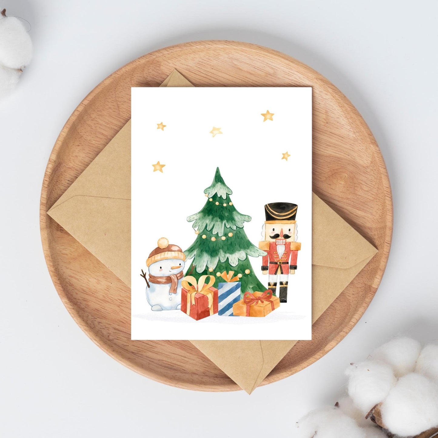 Weihnachtskarte Schneemann & Nussknacker A6: Karte mit Weihnachtsbaum, Geschenken und Schneemann auf einem Holzteller. Hochwertiges, mattes Naturpapier. Rückseite beschreibbar.