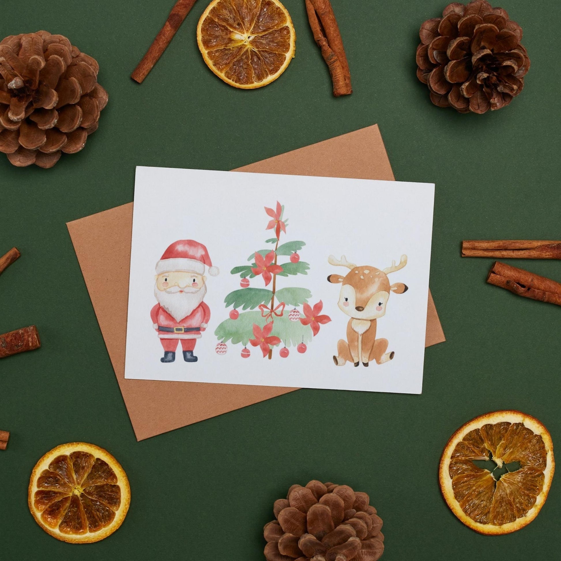 Weihnachtskarte Weihnachtsmann & Rentier A6: Santa und Rentier. Umgeben von Tannenzapfen und Orangenscheiben. Gedruckt auf hochwertigem, mattem 300g Naturpapier.