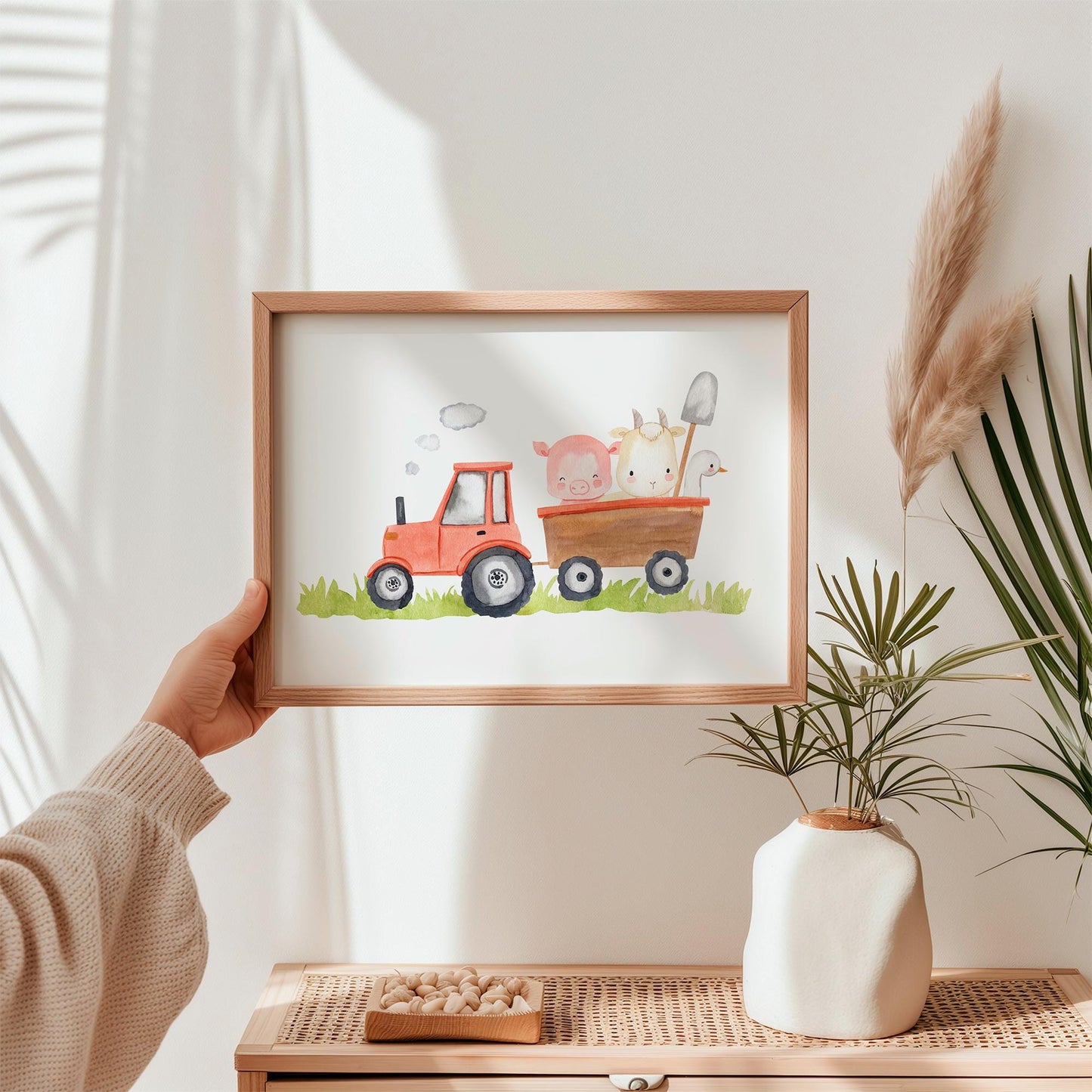 Poster Traktor und Tiere A3 & A4: Person hält ein Bild mit Traktor und Tieren, ideal als Kinderzimmer-Deko auf hochwertigem, mattem 300g Naturpapier.