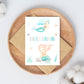 Einschulung Geschenk-Set Meerjungfrauen mit Karte auf Teller, mermaid Illustrationen, ideal für den Schulstart, beinhaltet Stundenplan, Lesezeichen, Karte und Sticker.