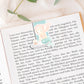 Einschulung Geschenk-Set Meerjungfrauen: Buch mit Meerjungfrau-Illustration, umgeben von Lesezeichen und Stickern im passenden Design für den ersten Schultag.