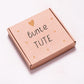 Quadratische Kraftpapierbox mit dem Schriftzug „bunte TÜTE“ und Herzsymbol. Überraschungsbox mit über 40 Euro Warenwert, bestehend aus B-Ware und fehlerfreien Produkten.