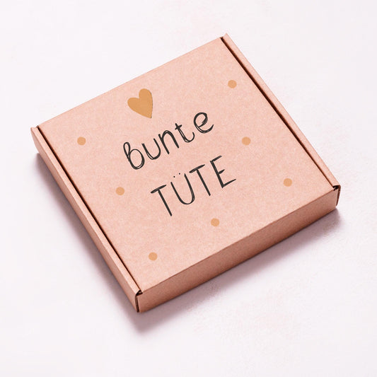 Quadratische Kraftpapierbox mit dem Schriftzug „bunte TÜTE“ und Herzsymbol. Überraschungsbox mit über 40 Euro Warenwert, bestehend aus B-Ware und fehlerfreien Produkten.