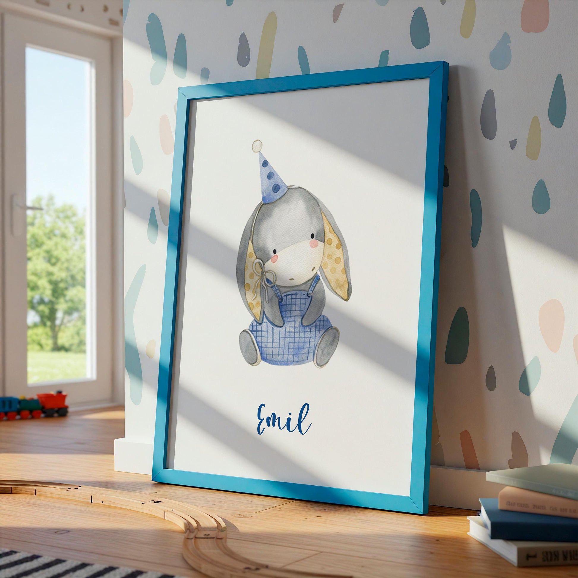 Geburtsposter Esel personalisiert: Aquarell-Hase im blauen Rahmen, mit Namen Emil, Spielzeugzug, Bücher, und natürlichem Licht im Kinderzimmer.