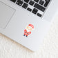 Sticker Weihnachtsmann auf einem silbernen Laptop, zeigt einen handgefertigten, langlebigen Vinyl-Aufkleber, ideal für personalisierte Weihnachtsdekorationen auf verschiedenen Oberflächen.