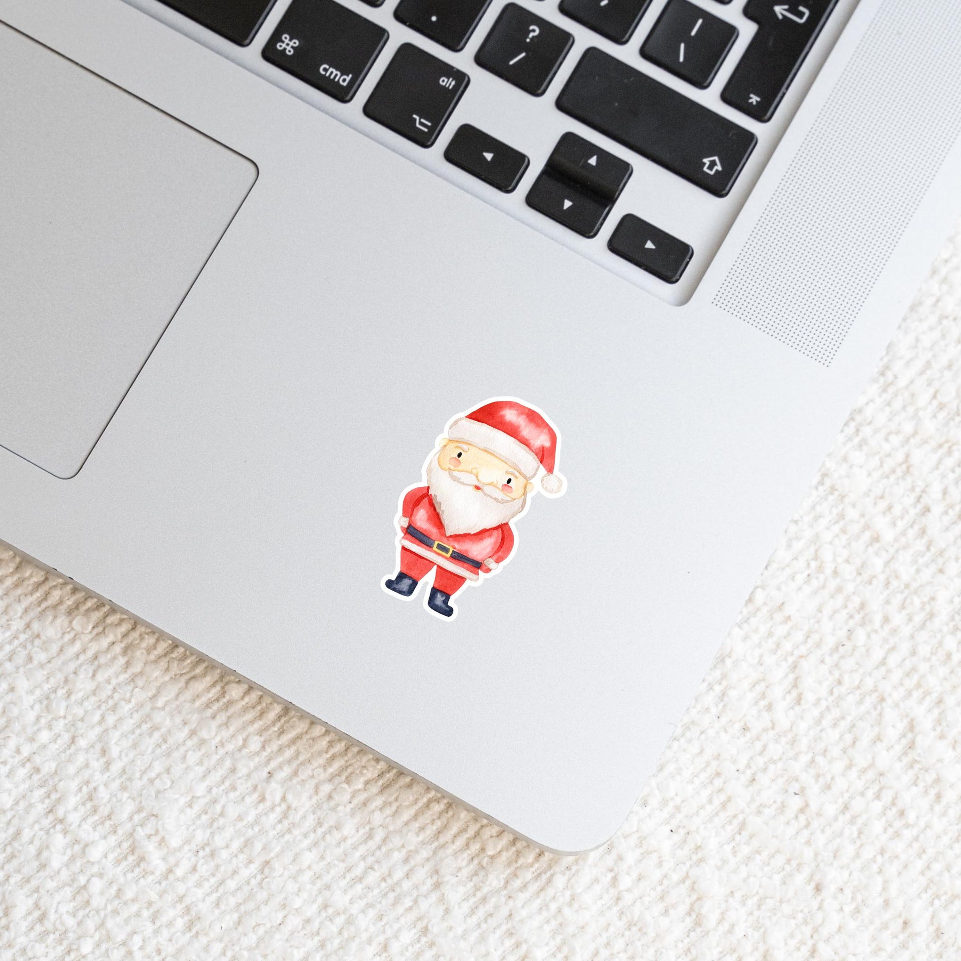 Sticker Weihnachtsmann auf einem silbernen Laptop, zeigt einen handgefertigten, langlebigen Vinyl-Aufkleber, ideal für personalisierte Weihnachtsdekorationen auf verschiedenen Oberflächen.