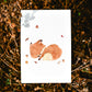 Postkarte Karte Fuchs & Herbstlaub A6 zeigt einen schlafenden Fuchs in Herbstlaub auf hochwertigem 300g Naturpapier. Ideal für Grüße oder Herbstdekoration.