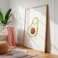 Namensposter Avocado A3 & A4: Ein großes Holzrahmenbild mit fröhlicher Avocado-Illustration und „Lina“, umgeben von Babyzimmerdekorationen wie einem weißen Kinderbett und Pflanzen.